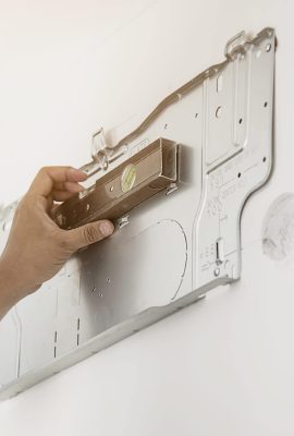 Technician is checking level while installing air conditioner during hot season